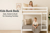 White wooden kids bunk beds with smiling children in a cozy bedroom, styled for safety and growing families